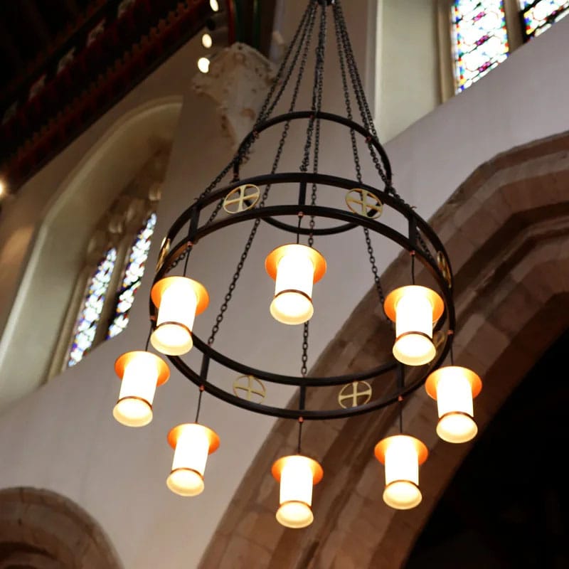 Ornate church chandelier with glowing lamps